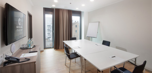 Kleiner Tagungsraum mit Tischen, Stühlen und Whiteboard
