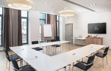 Moderner Seminarraum mit Sitzplätzen in U-Form, Whiteboard und Flachbildschirm
