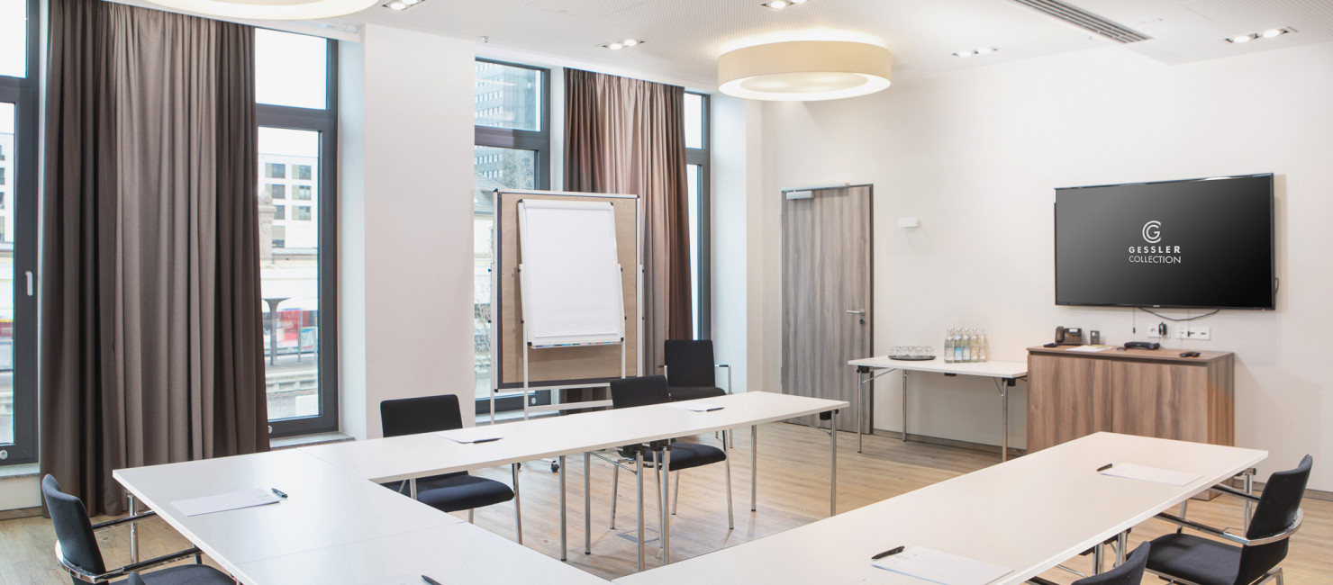 Moderner Tagungsraum mit Flachbildschirm, Whiteboard und zahlreichen Sitzplätzen