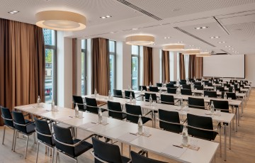 Moderner Tagungsraum mit zahlreichen Sitzplätzen und großer Fensterfront