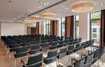 Tagungsraum mit zahlreichen Sitzplätzen und großer Fensterfront
